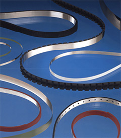 A variety of coated metal belts demonstrating different surface treatments