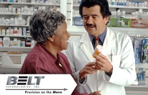 A woman speaks to a pharmacist who is holding and pointing to a pill bottle.